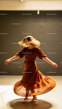 Woman Dancing Gracefully in Flowing Brown Dress