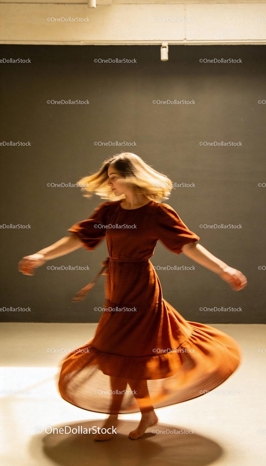 Woman Dancing Gracefully in Flowing Brown Dress