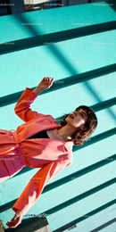 Stylish woman posing against turquoise wall outdoors