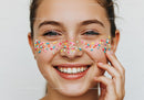 Smiling Woman with Colorful Sprinkles on Face in Playful Mood