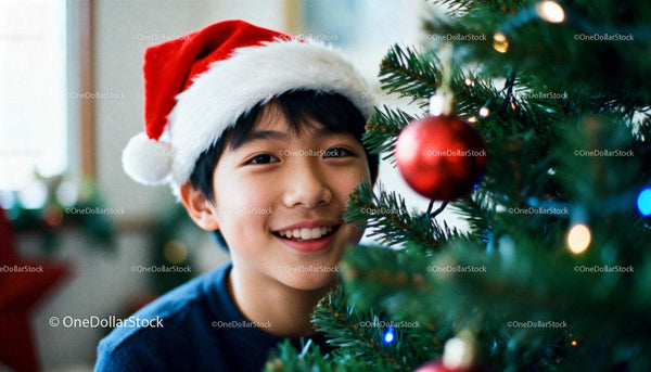 Smiling boy in Santa hat decorating Christmas tree