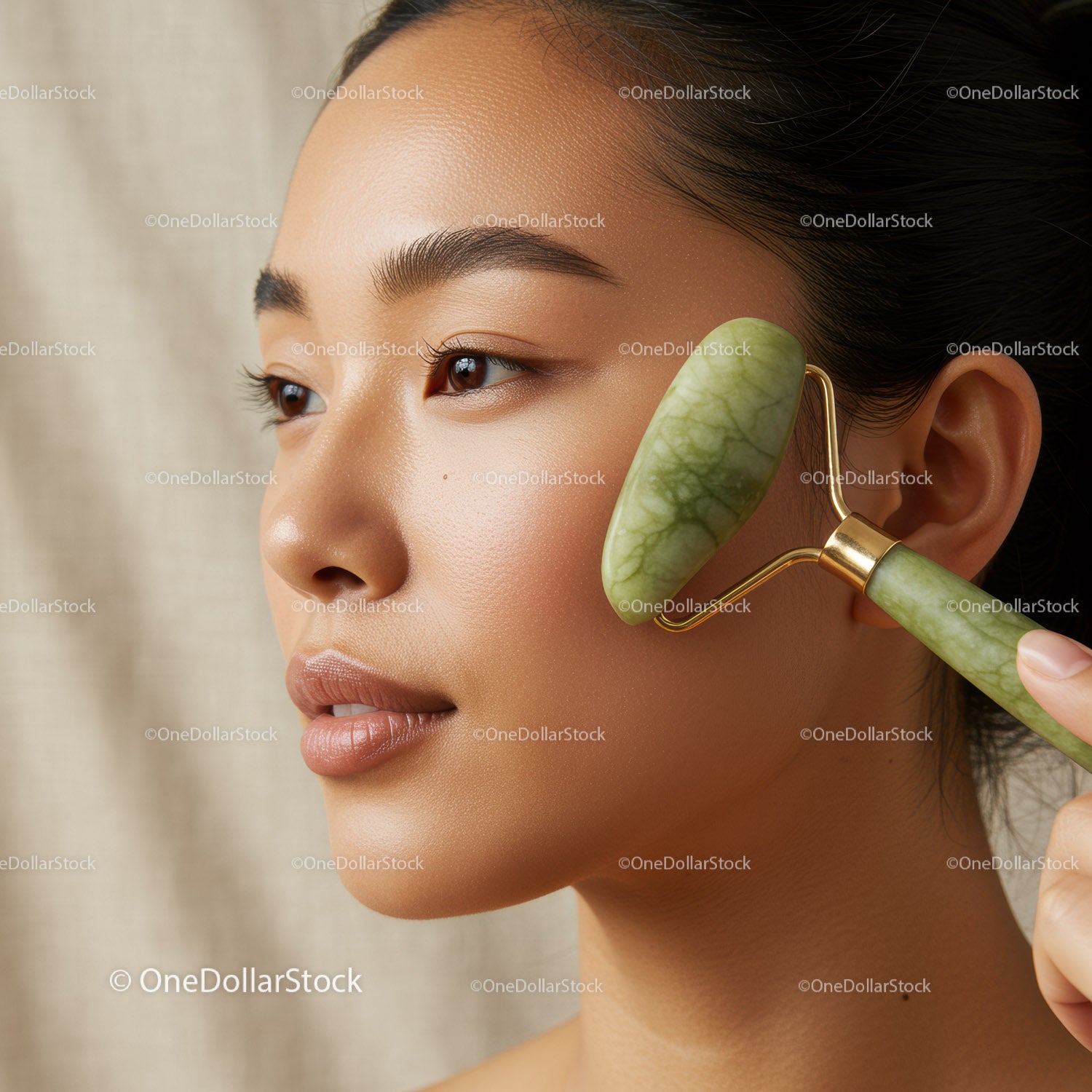Asian Woman Using Jade Roller for Facial Skincare and Relaxation