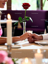 Couple Holding Hands Over Romantic Dinner Table