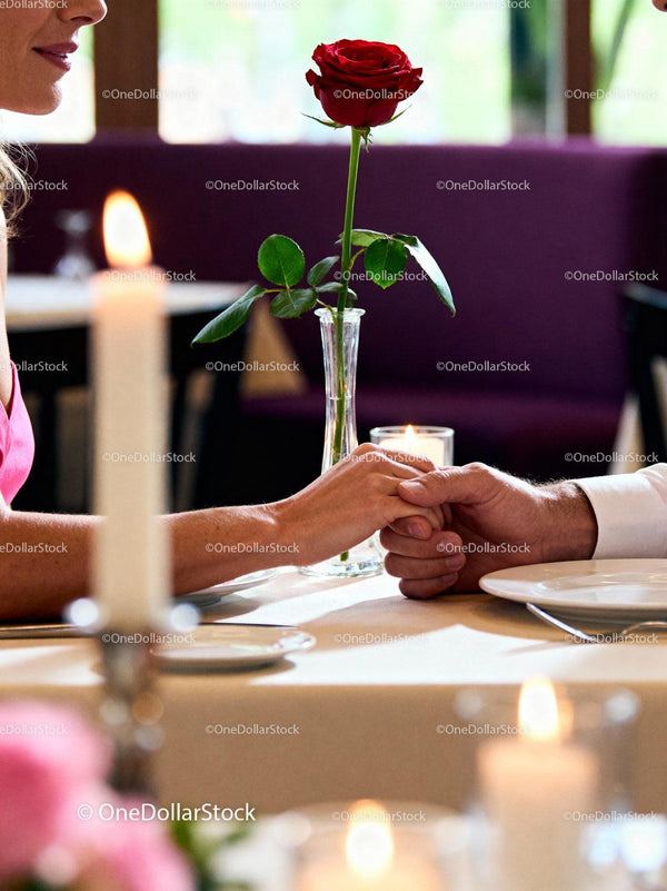 Couple Holding Hands Over Romantic Dinner Table