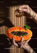 Hands Drizzling Honey Over Fresh Papaya Half