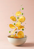 Crispy Potato Chips and Green Peas Flying Above Bowl