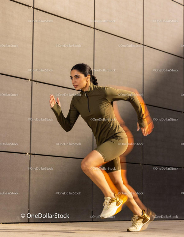 Athletic woman sprinting powerfully outdoors in urban setting