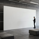 Man using smartphone near empty white art wall in gallery