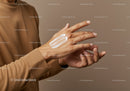 Woman Applying Hand Cream in Skincare Routine with Neutral Background