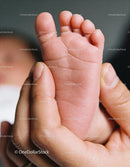 Tender close-up of parent holding newborn baby's foot