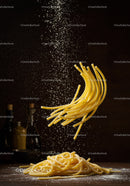 Fresh pasta strands with flour falling on wooden surface