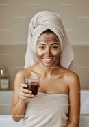 Young Woman Relaxing with Facial Mask and Towel Wrap