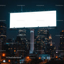 Illuminated blank billboard in urban night cityscape