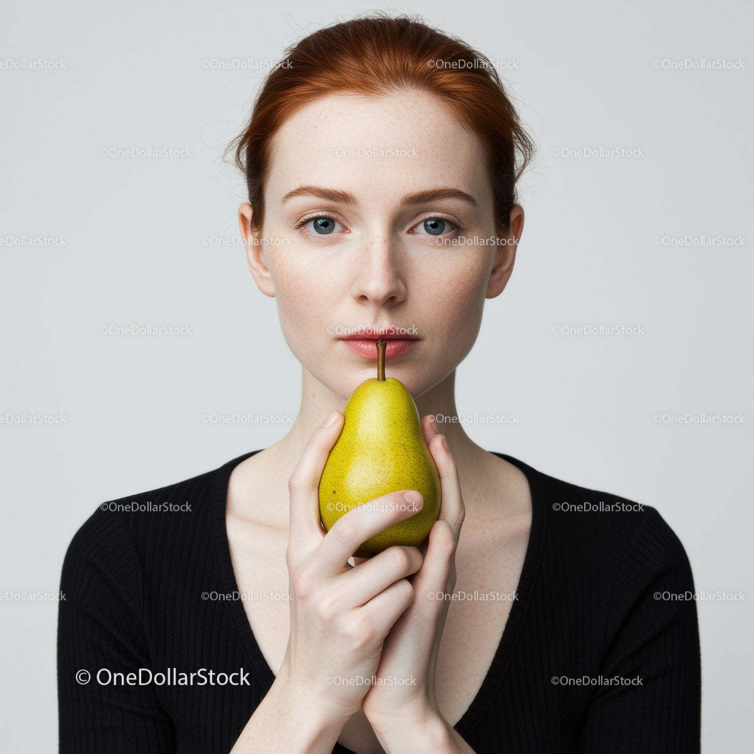 Portret młodej kobiety z rudymi włosami trzymającej organiczną gruszkę