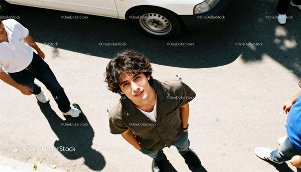 Casual young man looking up on sunny street