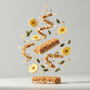 Healthy granola bar with banana slices and seeds levitating