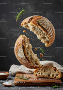 Rustic sourdough bread breaking apart with fresh rosemary