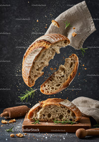 Rustic sourdough bread breaking apart in motion
