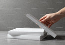 Hand Picking a Book from a Stack on Gray Surface