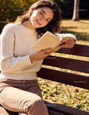 Young woman enjoying a book on a sunny park bench