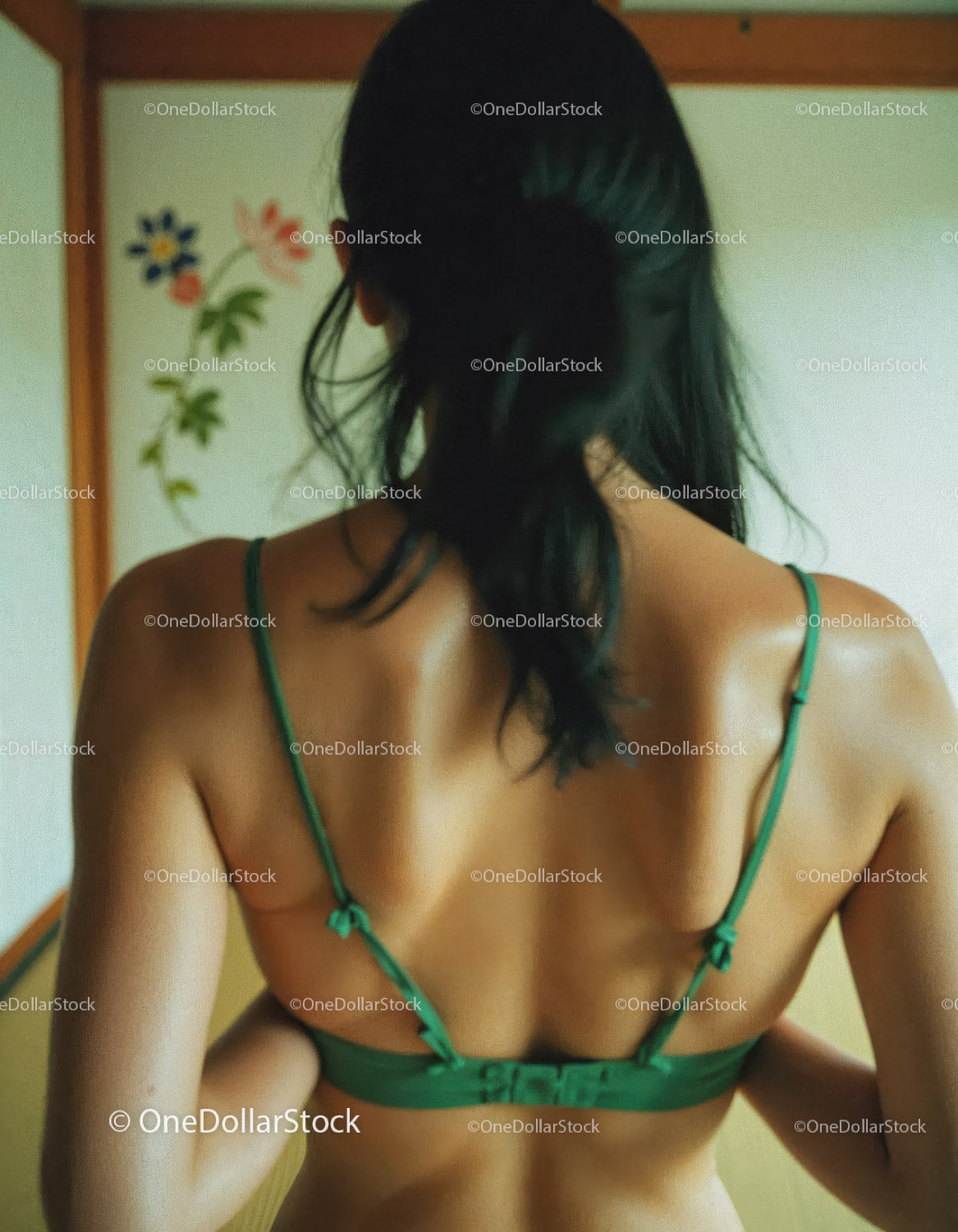 Woman in Green Lingerie with Back View in Cozy Indoor Setting