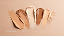 Various foundation and powder makeup swatches on beige