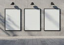 Three blank vertical posters on modern concrete wall