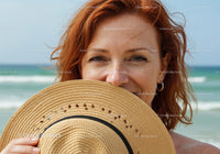 Smiling Red-Haired Woman with Straw Hat at the Beach