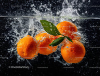 Bright oranges with fresh green leaves in water splash