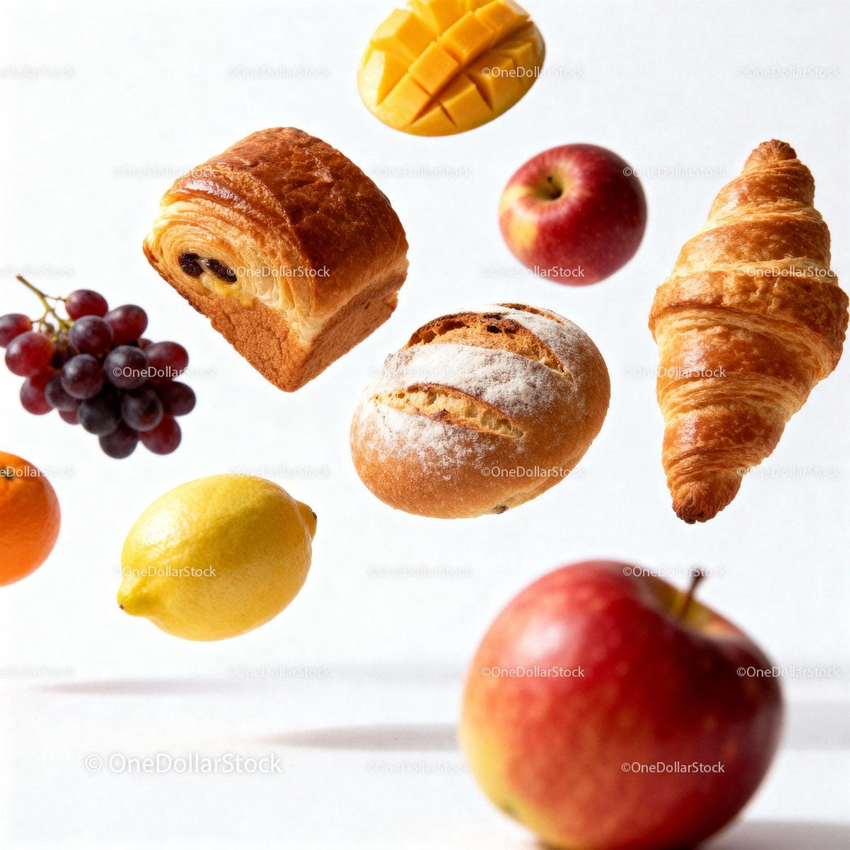 Assorted fresh fruits and bakery items floating on white