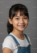 Portrait of a Smiling Girl with Braces Wearing Denim Overalls