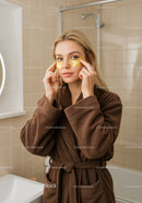 Young Woman Applying Under Eye Patches in Bathroom for Skincare