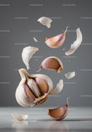 Floating garlic cloves and peeling in midair on gray