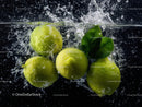 Fresh Green Apples Splashing into Water with Leaves