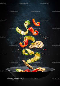 Grilled vegetables tossed midair over black pan
