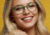Smiling woman wearing green glasses and pearl accessories
