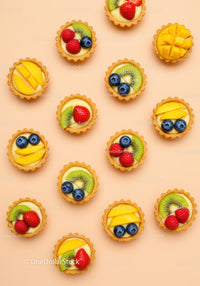 Assorted Mini Fruit Tarts on Peach Background