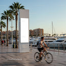 Sunny Marina Promenade with Cyclist and Blank Billboard