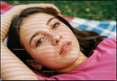 Young woman resting outdoors with soft sunlight pattern