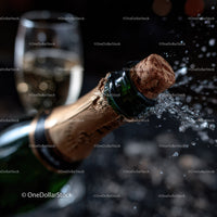 Champagne Bottle with Popping Cork and Bubbles in Dark Setting