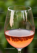 Close up of rose wine glass with natural green background