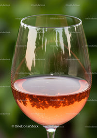 Close up of rose wine glass with natural green background