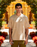 Serious young man standing in sunlit garden courtyard