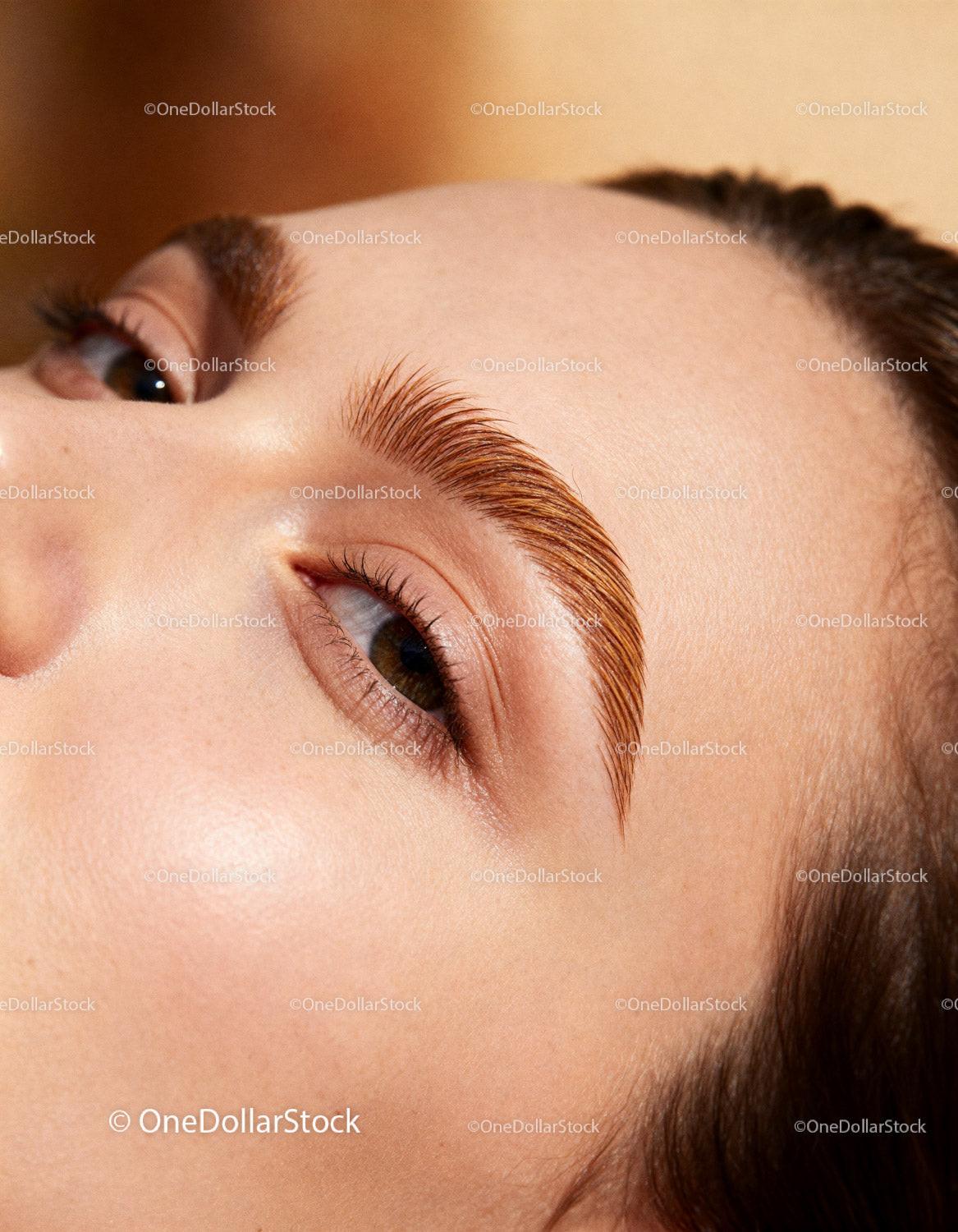 Close up of woman with well-groomed eyebrows and glowing skin