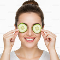 Smiling Woman Holding Cucumber Slices Over Eyes for Skincare and Relaxation