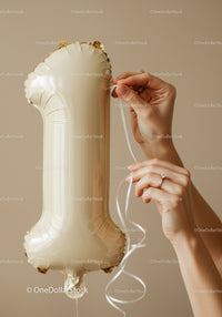 Hands tying ribbon on number one shaped balloon