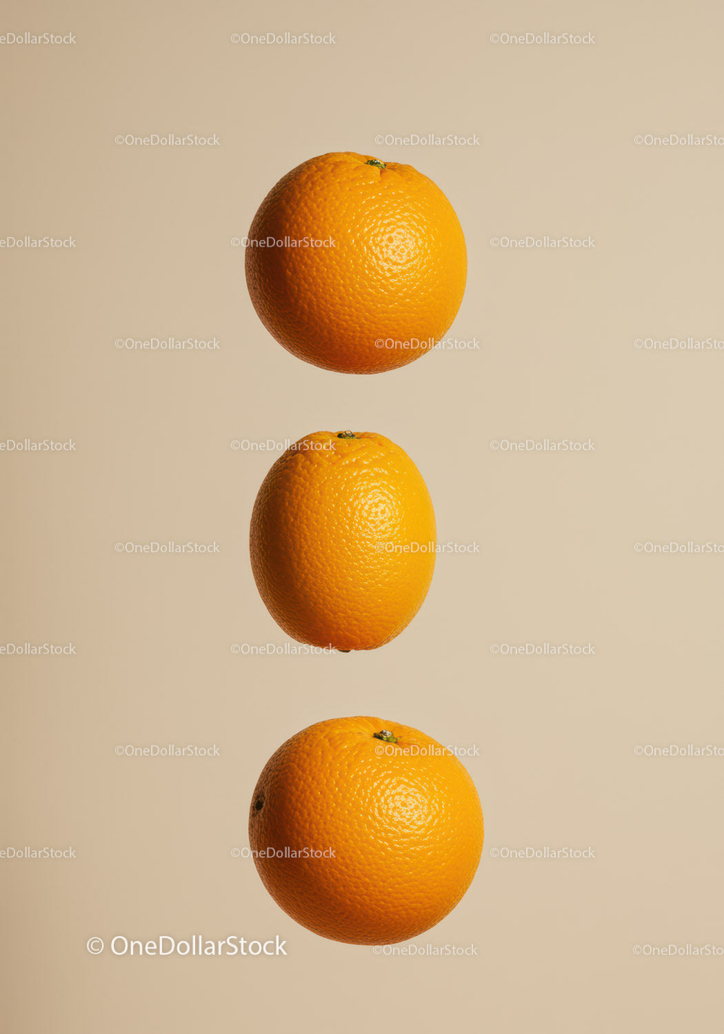 Three fresh oranges aligned on beige background