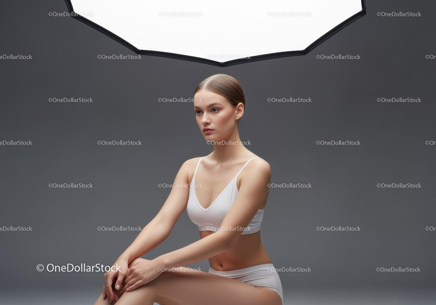 Elegancki portret studyjny młodej kobiety w białym stroju sportowym w nowoczesnym otoczeniu