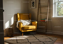Cozy sunlit corner with yellow armchair and ladder bookshelf