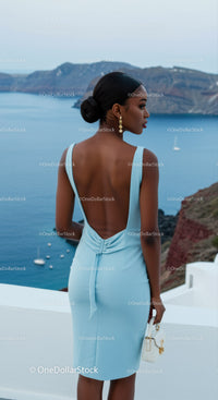 Elegant woman in blue dress overlooking ocean view